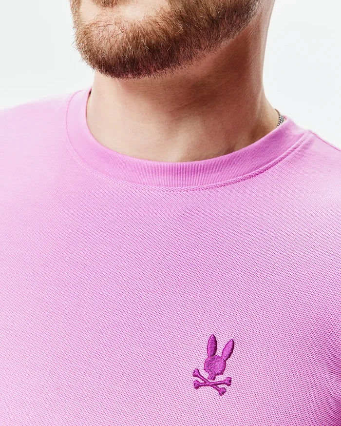 Mens Taylor Pique Tee in vibrant pink, classic fit, with a textured pique knit and a small, embroidered magenta Psycho Bunny skull logo on the left chest.