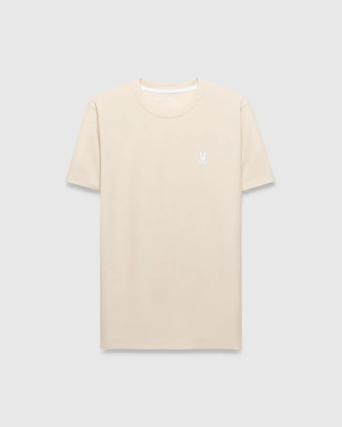 Mens Taylor Pique Tee in cream, featuring a classic fit and subtle pique texture. A small, white embroidered Psycho Bunny skull logo adorns the left chest.