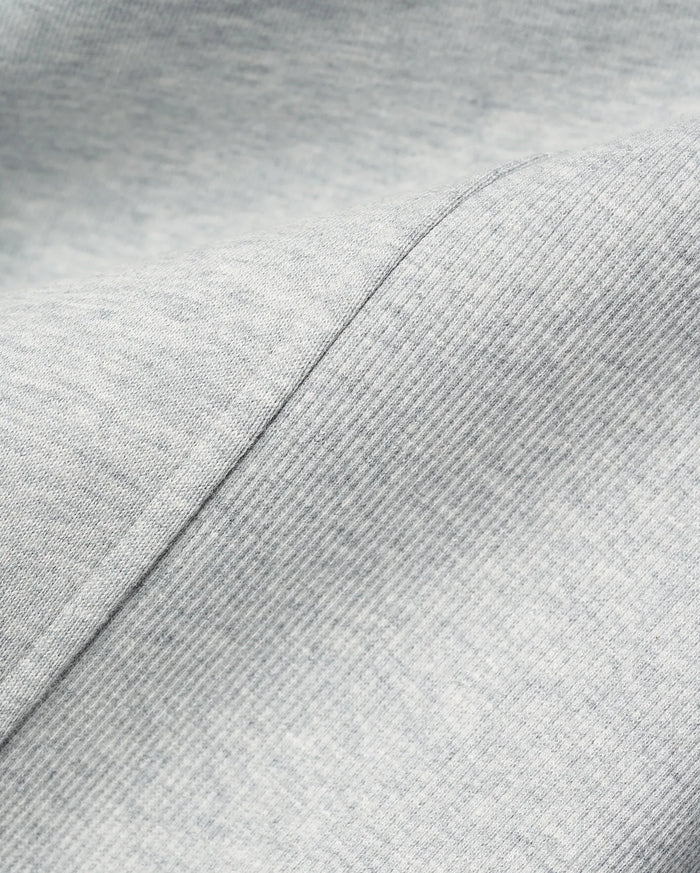 MENS TERRENCE FLEECE HOODIE in light grey heather, showcasing a soft, heathered fleece fabric with a distinct diagonal seam separating it from a finely ribbed texture, emphasizing comfort.