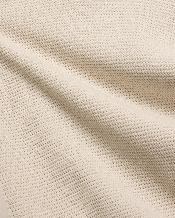 Mens Theros Knit Polo in a luxurious cream hue, showcasing a premium, breathable pique knit fabric with a subtle, sophisticated texture, ideal for refined streetwear.