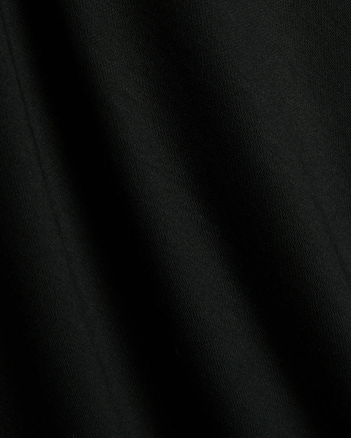 Premium black Mens Timmy Interlock Polo fabric, showcasing a smooth, dense interlock knit with subtle texture and refined drape, embodying Psycho Bunny's sophisticated streetwear style.