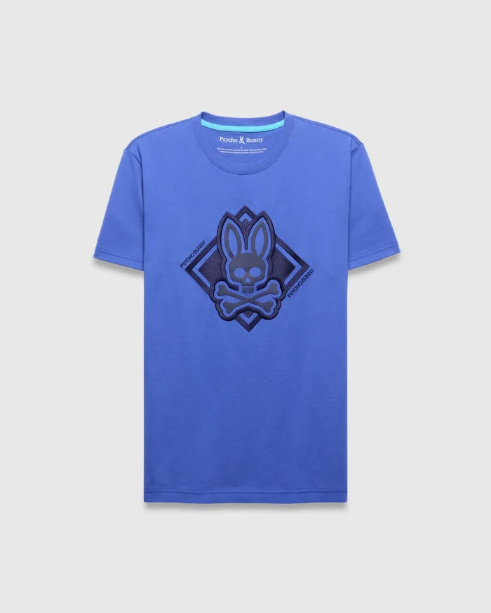 Mens Tobias Graphic Tee, royal blue classic fit jersey t-shirt featuring a large central dark blue textured bunny skull logo within a diamond outline, flanked by diagonal Psycho Bunny text.