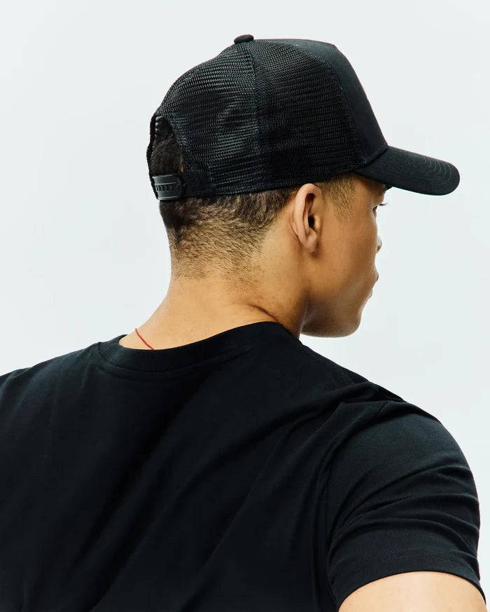 Black classic fit jersey t-shirt with a crew neck, paired with a black Mens Tobias Trucker Cap featuring a breathable mesh back and adjustable snap closure.