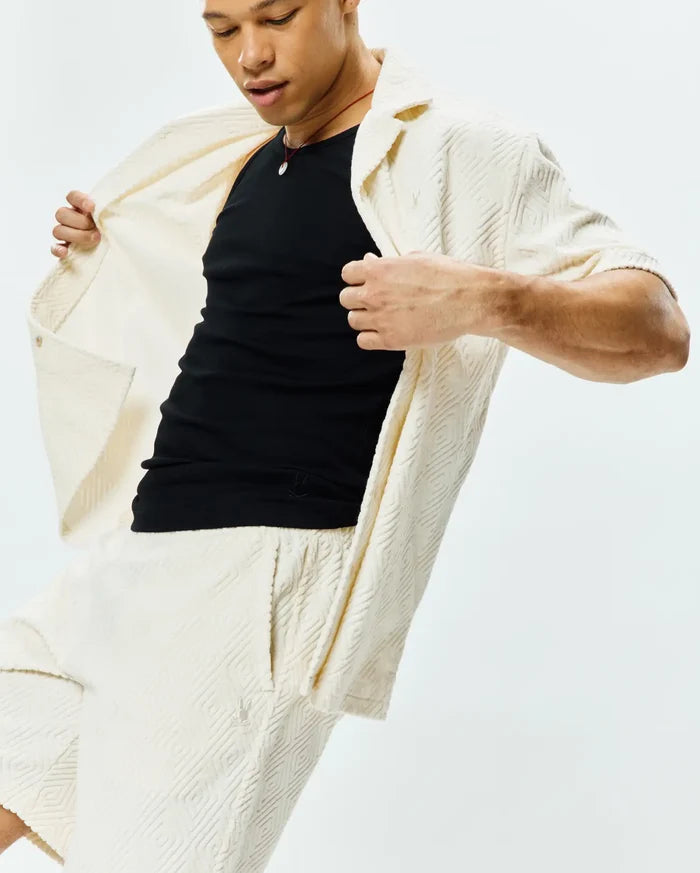 Mens Tristan Short and matching cream relaxed-fit short-sleeve shirt, both in soft textured knit with an all-over geometric diamond pattern and a small embroidered Psycho Bunny skull logo on the left thigh.