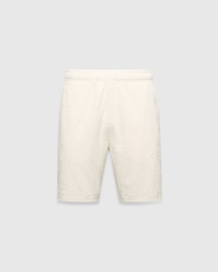 Mens Tristan Short in cream, a relaxed fit short with an all-over raised geometric concentric square pattern on textured fabric, no visible Psycho Bunny logo.