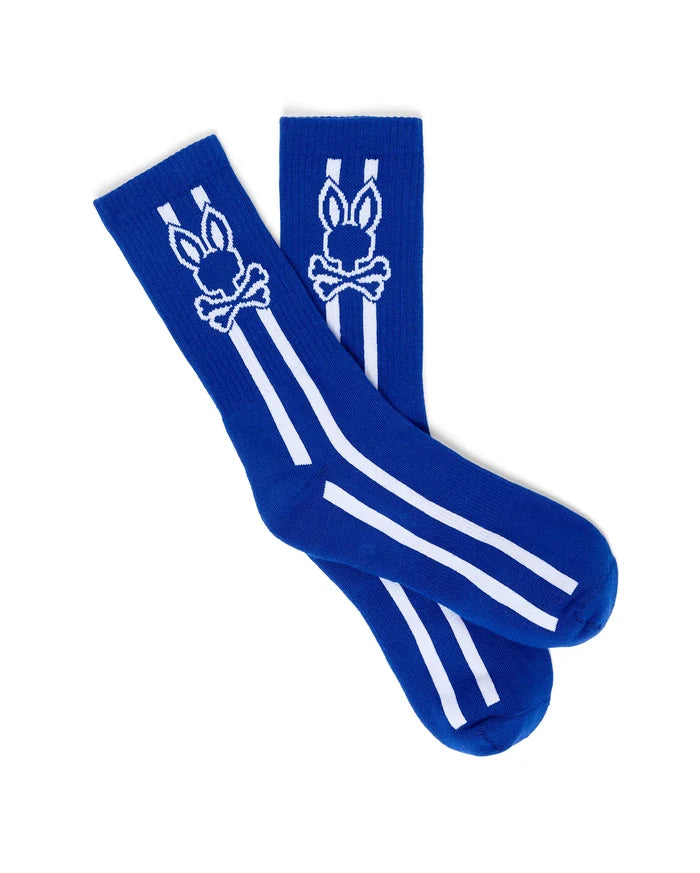 Mens Ty Sport Sock in vibrant royal blue knit, featuring a prominent white Psycho Bunny skull logo graphic on the calf, flanked by two vertical white stripes and two horizontal white stripes below.