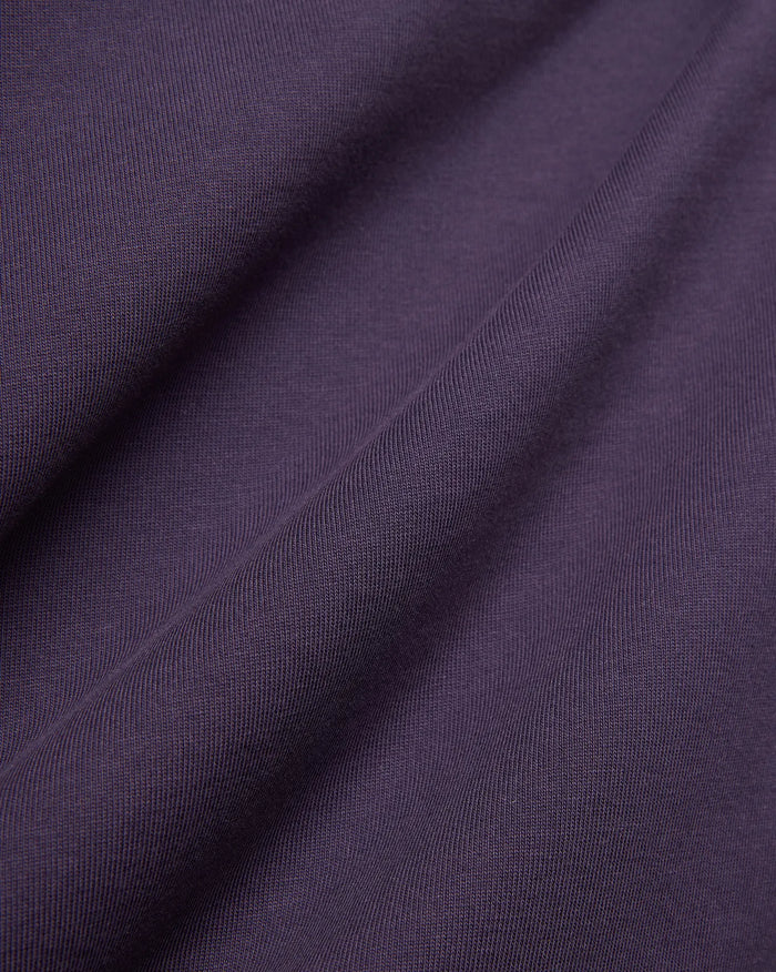 Dark Purple Mens Windcrest Relaxed Fit Tee fabric, featuring a soft, finely ribbed jersey knit texture with subtle vertical lines and gentle folds.