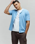 Mens Xandros Knit Shirt in sky blue, featuring a textured checkerboard knit pattern, classic fit, spread collar, full button-front, and a small embroidered Psycho Bunny skull logo on the left chest.