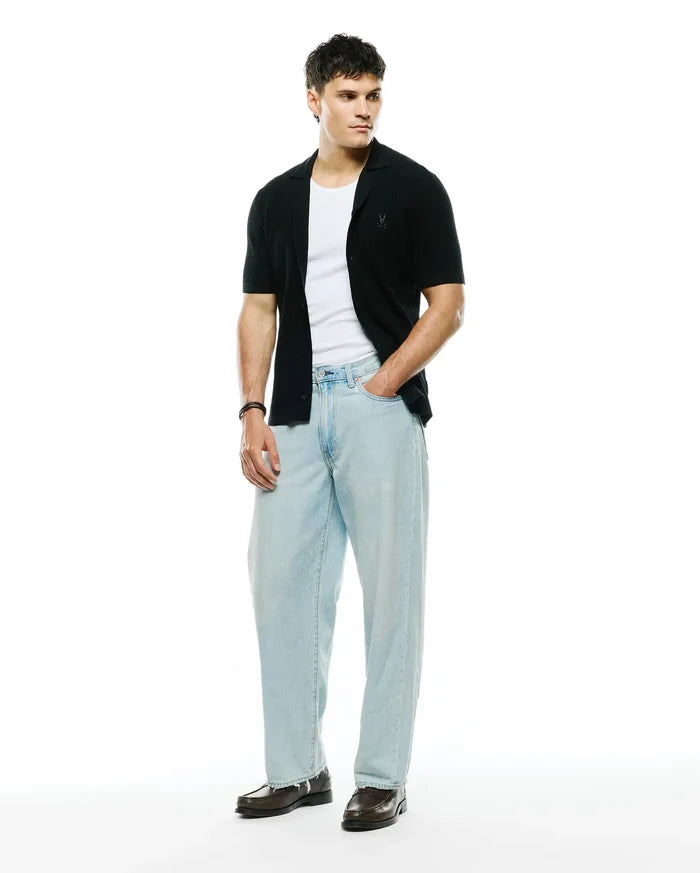 Mens Yann Knit Shirt, black ribbed knit, classic fit, short-sleeve button-front with camp collar and small embroidered Psycho Bunny skull logo on left chest.