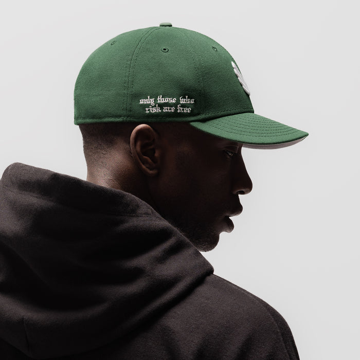 New Era 59Fifty Low Profile Hat in forest green with white wings logo, side profile view on model