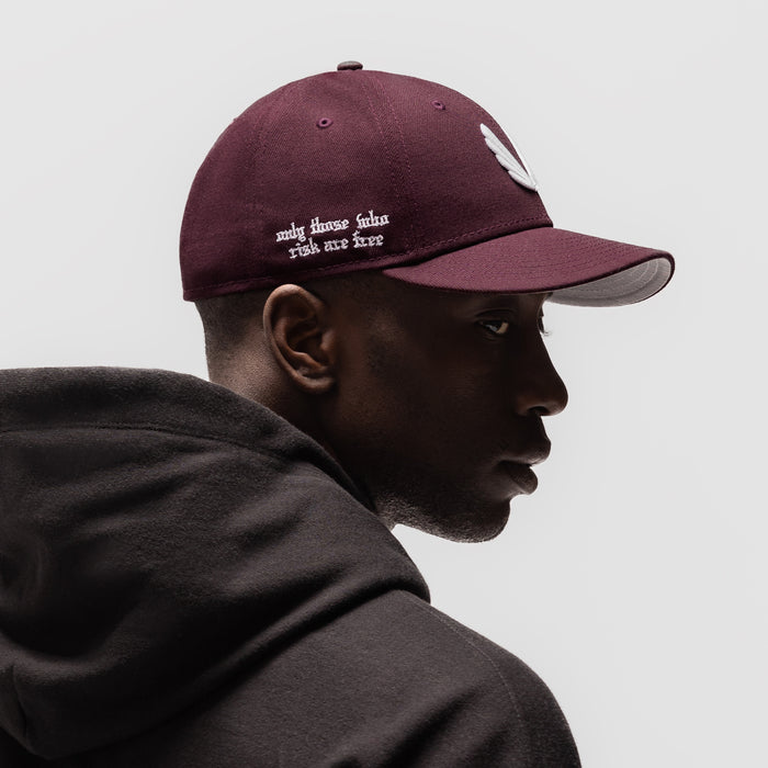 New Era 59Fifty Low Profile Hat in maroon with white wings logo, worn by model in profile view