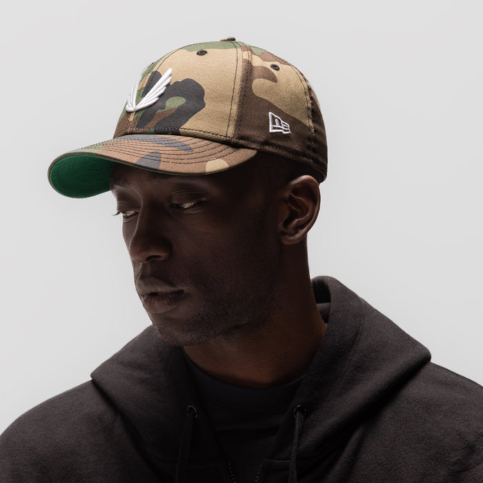 New Era 59Fifty Low Profile Hat in woodland camo with white wings logo, worn by model