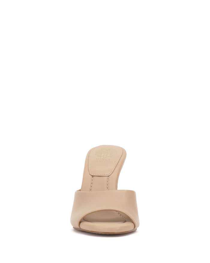 Front view of the Paigely Mule by Vince Camuto in beige, featuring a wide front strap, flared heel, and cushioned pillow footbed, displayed on a white background for a minimalist mule look.