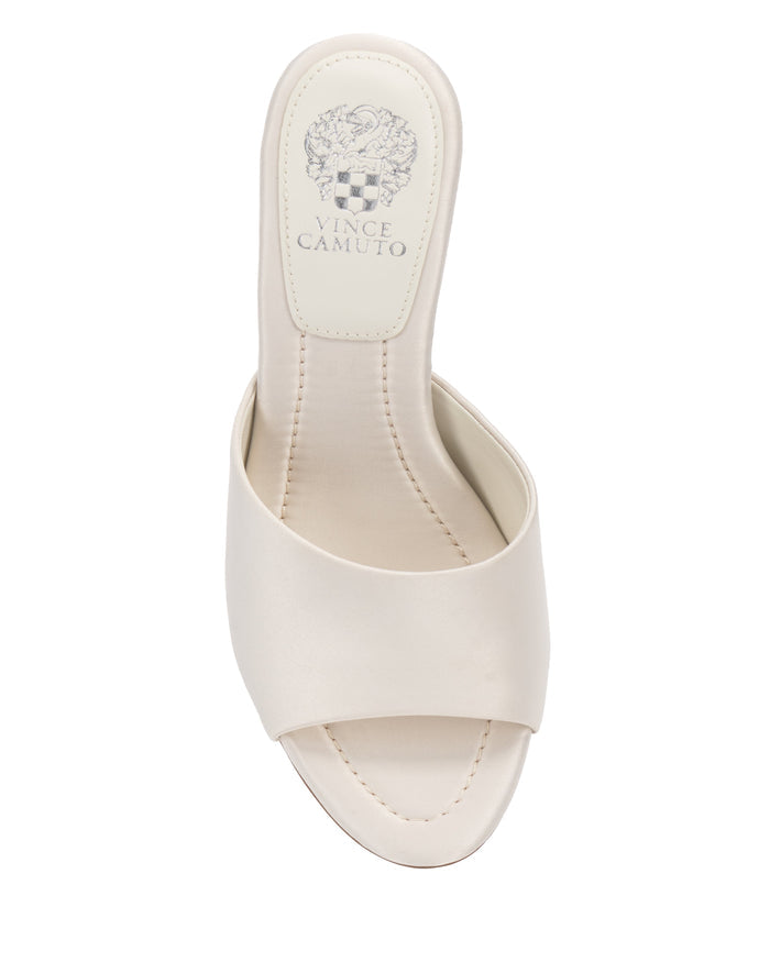 Introducing the Paigely Mule by Vince Camuto—a beige open-toe slide sandal designed with a wide strap, stitched insole, signature Vince Camuto logo on the heel pad, and a luxuriously cushioned pillow footbed for all-day comfort.