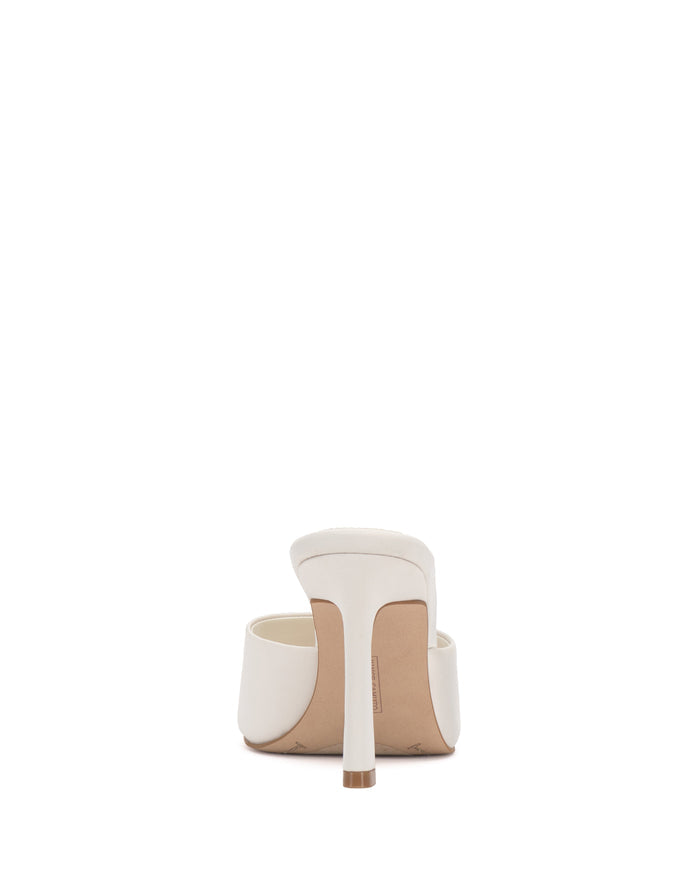 The Vince Camuto Paigely Mule is shown from the back against a plain white background, highlighting its white satin finish, flared heel, sole, and a glimpse of the plush pillow footbed.