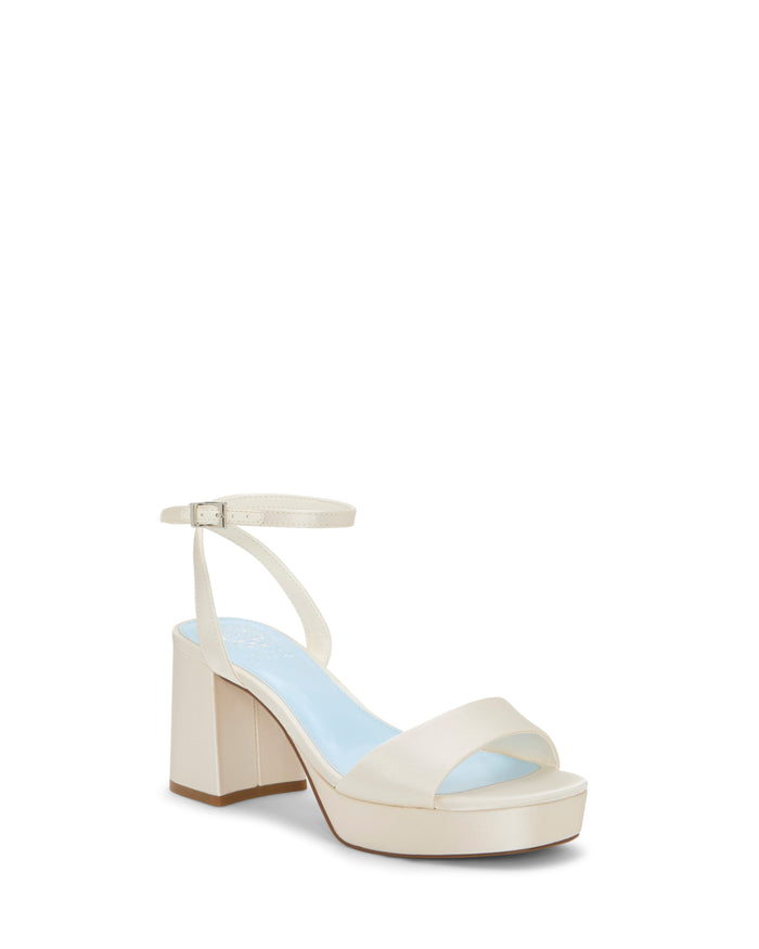 The Pendreya Platform Sandal by Vince Camuto features a cream-colored, open-toe block heel design with a single front strap and an adjustable ankle strap. Set against a plain white background, these retro-inspired sandals blend timeless elegance with modern comfort.