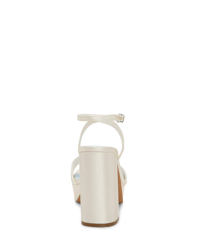 A rear view of the Vince Camuto Pendry Platform Sandal in white showcases its high block heel, ankle strap with buckle, and is displayed against a plain white background.