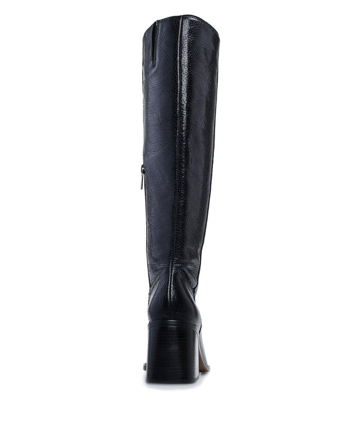 A black Vince Camuto Sangeti Wide Calf Boot in leather, featuring a side zipper and a sturdy block heel, is displayed from the back against a white background.