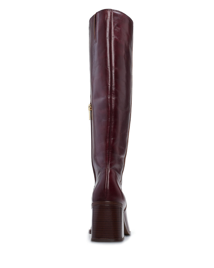The Vince Camuto Sangeti Wide Calf Boot, crafted in burgundy leather with a low block heel and side zipper, is showcased from the back against a white background—an elegant example of refined tall boot style.