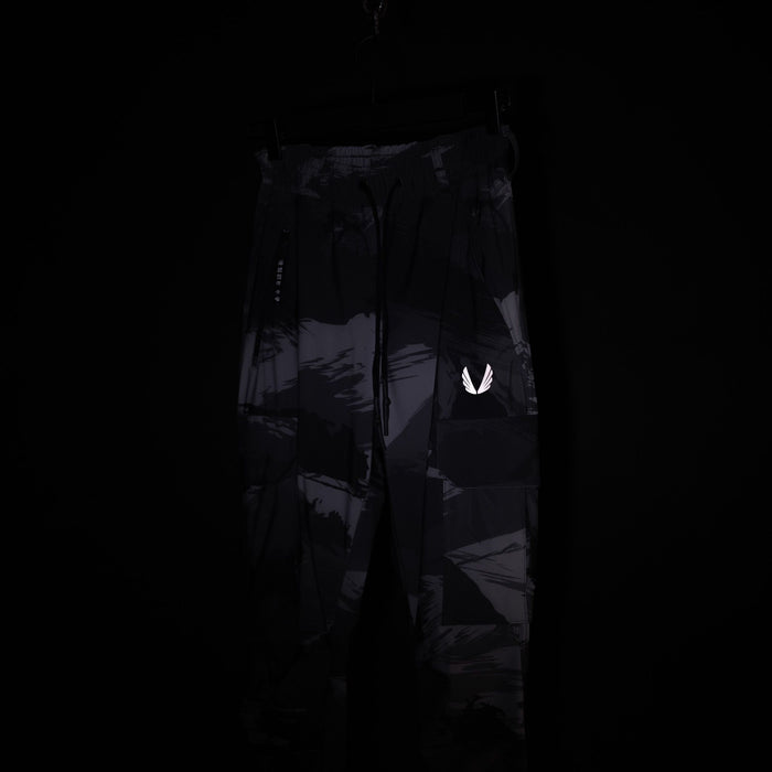 SM'20 Cargo High Rib pants in black with reflective logo, displayed on model against dark background
