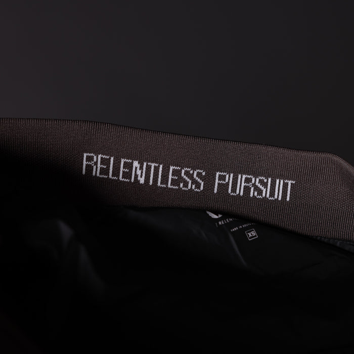 SP'23 Waterproof Run Vest in black, detail shot of neck label with 'Relentless Pursuit' text