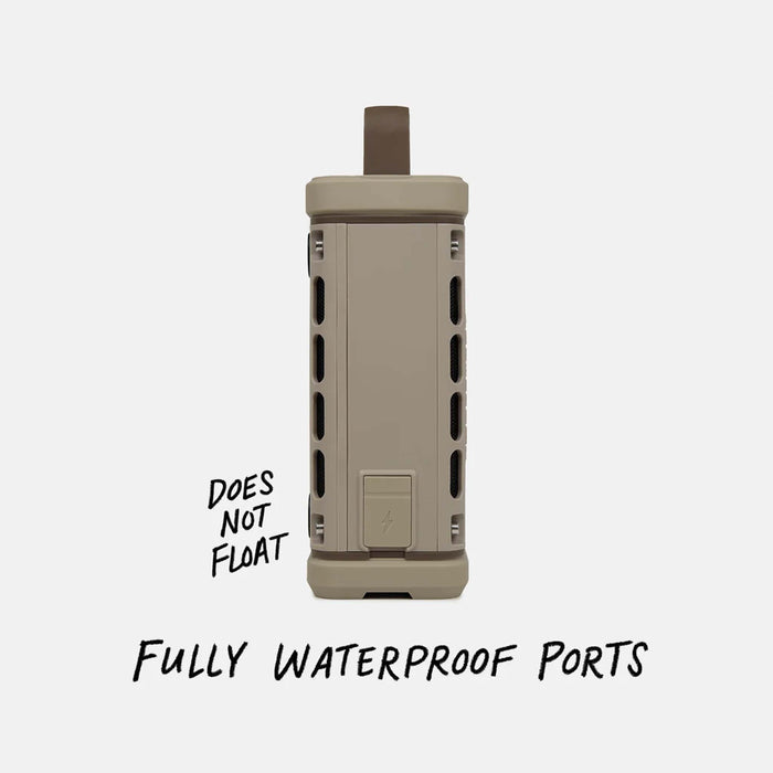 Side view of the Turtlebox Ranger speaker in tan showing waterproof charging port cover. Text reads “Does Not Float” and “Fully Waterproof Ports.”