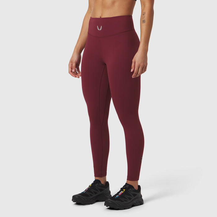W002 LYCRA® ADAPTIV Legging in crimson, worn by model with black sneakers, side view