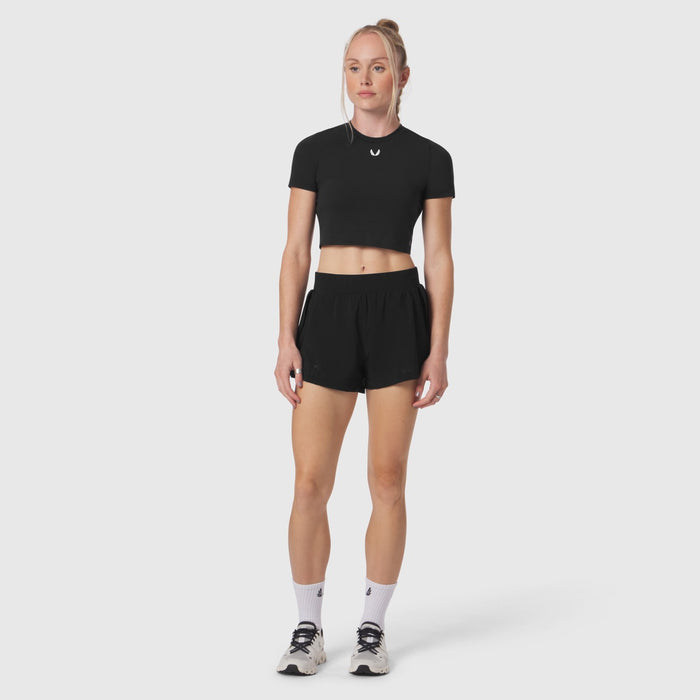 Black cropped tee worn by model with black shorts and white socks, front view