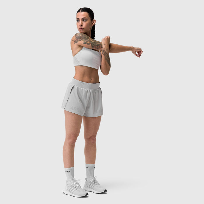 Aerotex Side Split Run Short in slate grey, worn by model demonstrating arm stretch pose