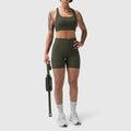 W029 LYCRA® 3-in-1 Biker Short in olive, worn by model standing with gym bag