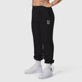 Black ripstop relaxed track pant worn with white sneakers and socks, side view