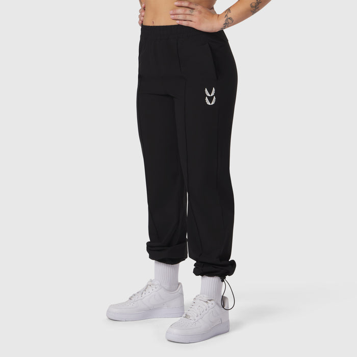 Black ripstop relaxed track pant worn with white sneakers and socks, side view