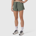 Tetra-Lite Linerless Short in sage, worn with white socks and sneakers, front view
