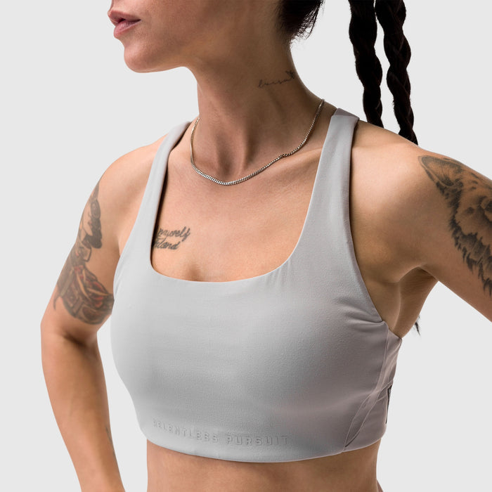Slate grey Lycra hybrid sports bra worn by model with tattoos, front view