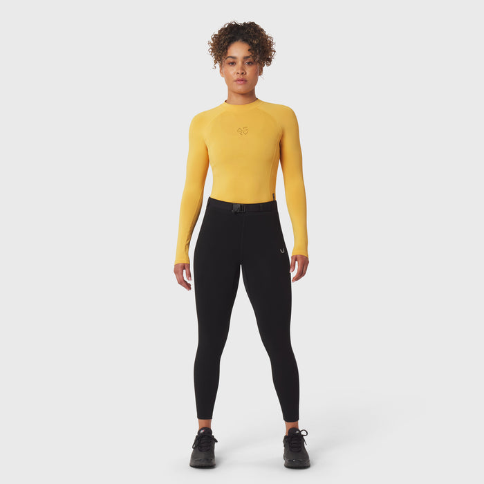 LYCRA® ADAPTIV baselayer longsleeve in amber worn with black leggings, front view