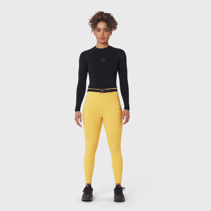 W059 Hybrid Belt-Pack Run Legging in amber yellow, worn with black long-sleeve top and black sneakers
