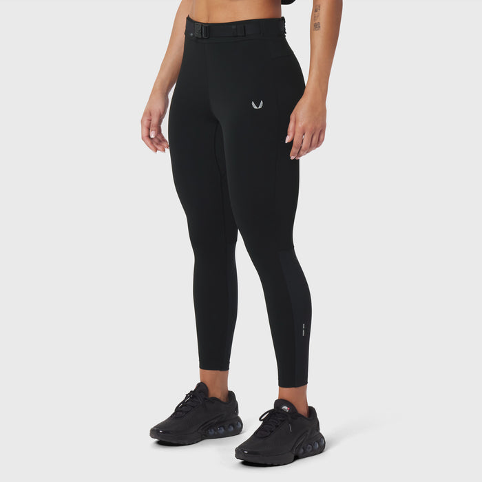 W059 Hybrid Belt-Pack Run Legging in black, worn by model with black sneakers, side view