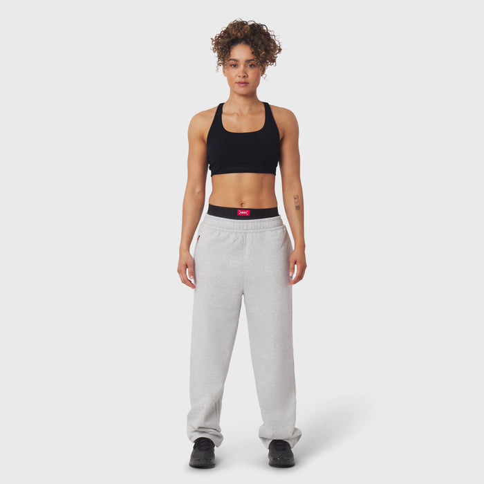 Model wearing black sports bra and grey joggers with black waistband detail, front view