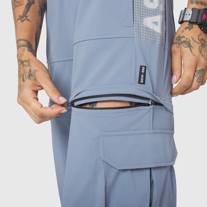 W100 2-in-1 Convertible Pant in Slate Blue, model demonstrating zippered pocket detail