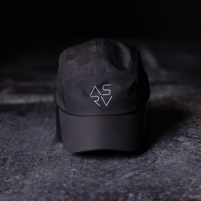 flatlay ASRV Vented Hat in black, angled front view on dark textured surface