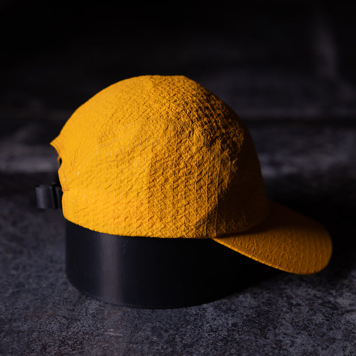 flatlay WN'23 5 Panel Hat in gold yellow with black band, top view