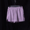 Flatlay of WN'23 6" Perforated Short in lavender purple, hung on hanger
