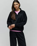 Womens Jules Lurex 1/4 Zip Pullover, a relaxed fit black lurex knit with subtle silver sparkle, featuring a stand collar, 1/4 zip closure, and a small embroidered black Psycho Bunny skull logo on the left chest.