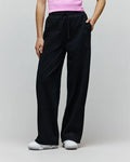 Womens Jules Lurex Sweatpant in black, featuring a relaxed wide-leg fit, shimmering lurex knit fabric, drawstring waist, and a small embroidered Psycho Bunny skull logo near the right pocket.