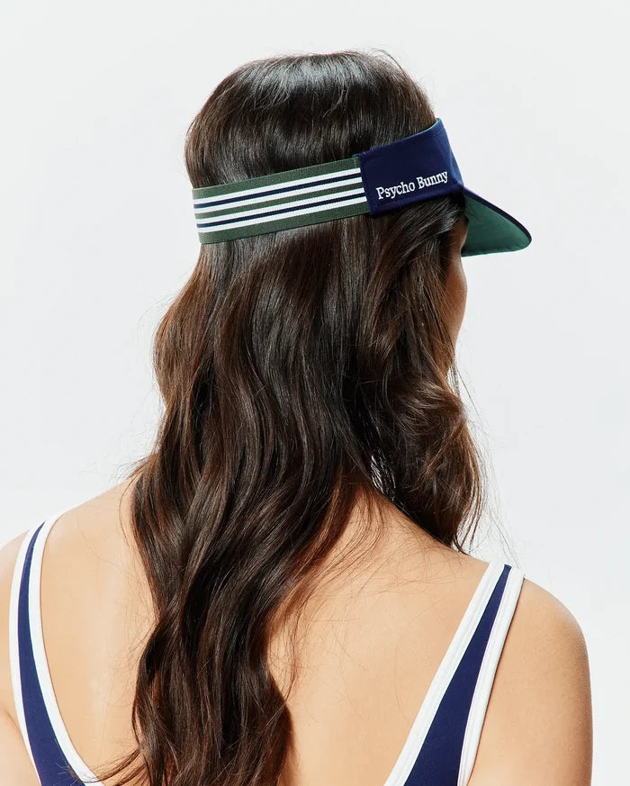 Women's Sport Visor in navy blue with a dark green underside brim, featuring a green, navy, and white striped elastic back strap and embroidered white Psycho Bunny text on the front.